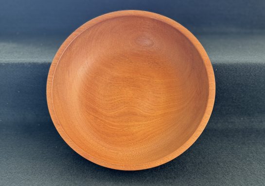 A smooth, wooden bowl with a natural finish and circular shape.