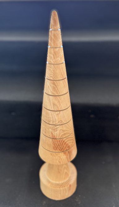 Wooden cone-shaped object with a rounded base and spiral grooves.