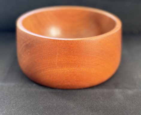 Round wooden bowl with a smooth, polished finish and a warm, reddish-brown colour.