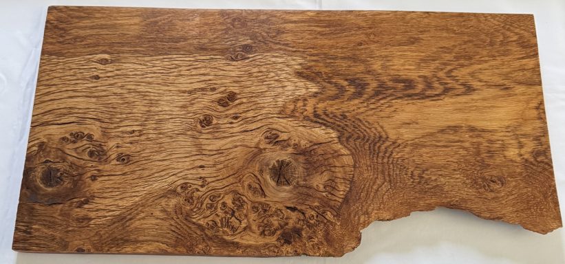 Wooden tabletop with a rich grain pattern and a natural edge.