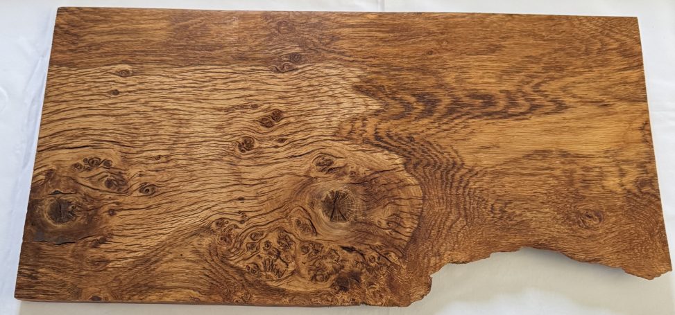 Wooden tabletop with a rich grain pattern and a natural edge.
