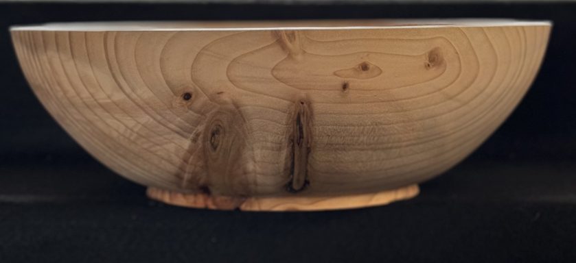 Light wooden bowl with a smooth finish and visible wood grain patterns.