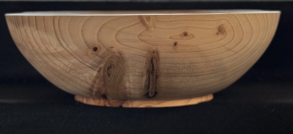 Light wooden bowl with a smooth finish and visible wood grain patterns.