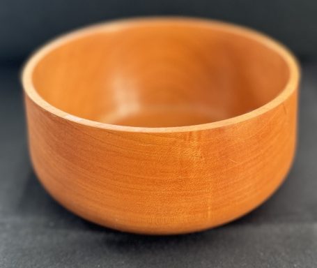 A smooth, round wooden bowl with a polished finish.