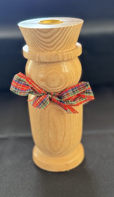A wooden vase with a decorative ribbon tied around the centre.