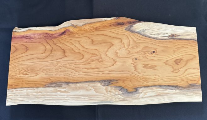 A smooth wooden slab with unique grain patterns and warm hues.