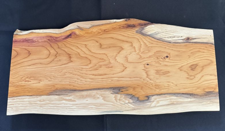 A smooth wooden slab with unique grain patterns and warm hues.