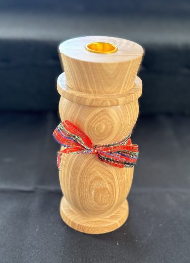 A wooden decorative piece with a ribbon wrapped around its midsection.