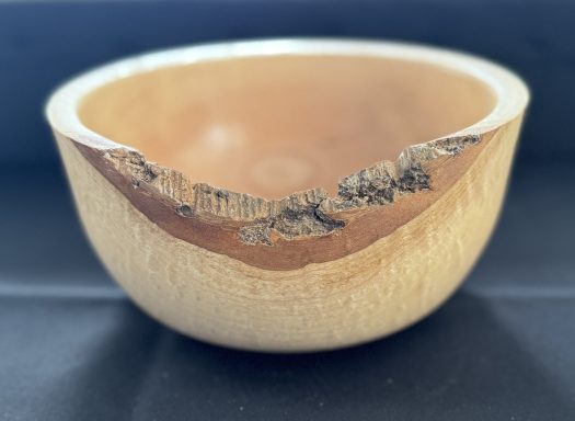 Wooden bowl with a natural, uneven edge and smooth inner surface.