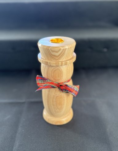 A wooden candle holder with a multicoloured ribbon tied around it.