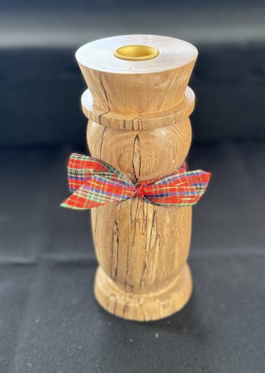 Wooden candle holder decorated with a colourful ribbon.