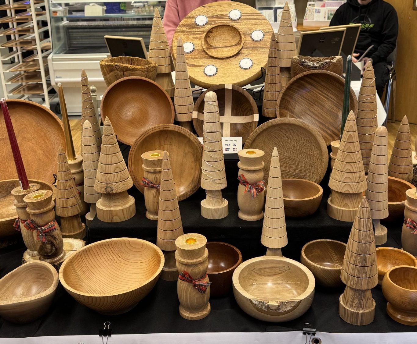 Various handcrafted wooden bowls and decorative items displayed in a market setting.