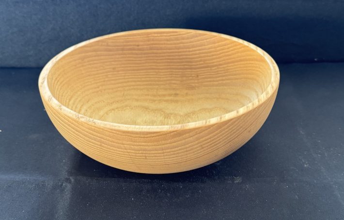 Light wooden bowl with a smooth, round interior and natural finish.