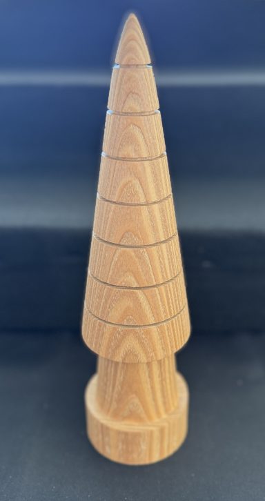 Wooden cone-shaped sculpture with concentric circular grooves.