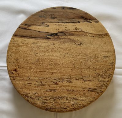Round wooden board with a natural finish and visible wood grain.