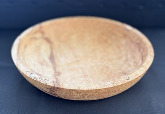 Round wooden bowl with a smooth, natural finish and subtle grain patterns.