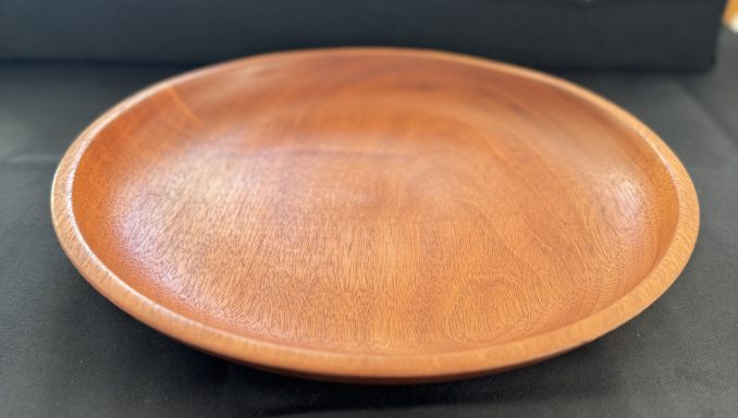 Round wooden plate with a smooth, polished surface.