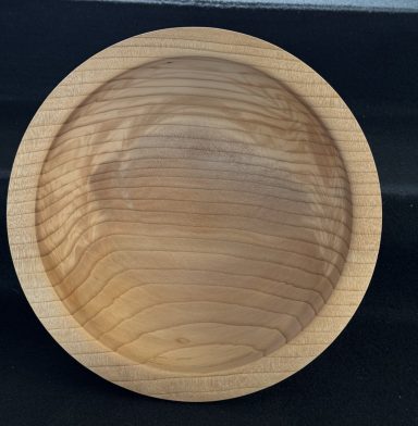 Round wooden bowl with a smooth surface and natural wood grain.