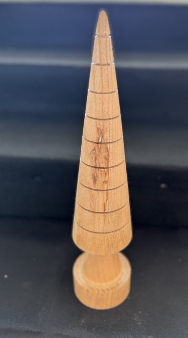 A conical wooden object with horizontal lines and a circular base.