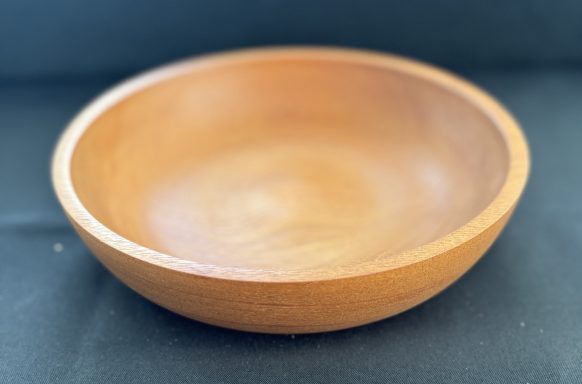A smooth, round wooden bowl with a warm brown finish.