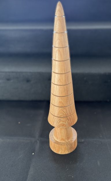 Wooden cone-shaped object with a textured surface and a circular base.
