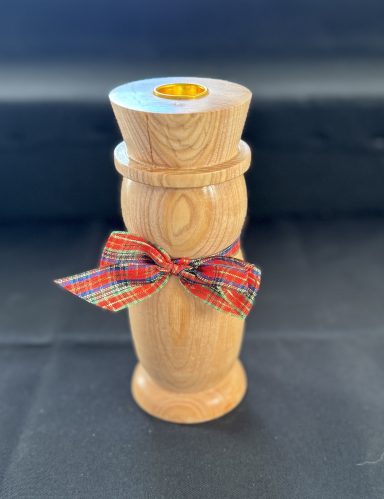 A wooden vase with a decorative ribbon tied around its middle.