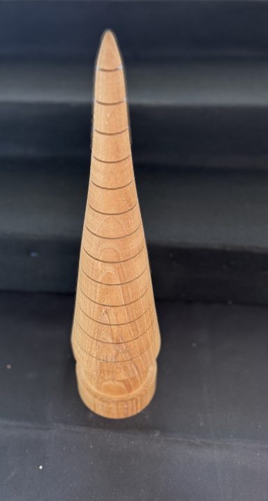 A conical wooden object with a ridged surface, resembling a crafted cone.