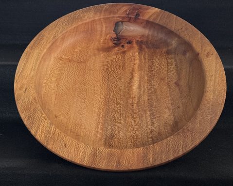 Round wooden bowl with a smooth finish and natural grain patterns.