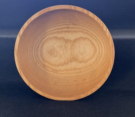 A smooth, round wooden bowl with visible grain patterns.
