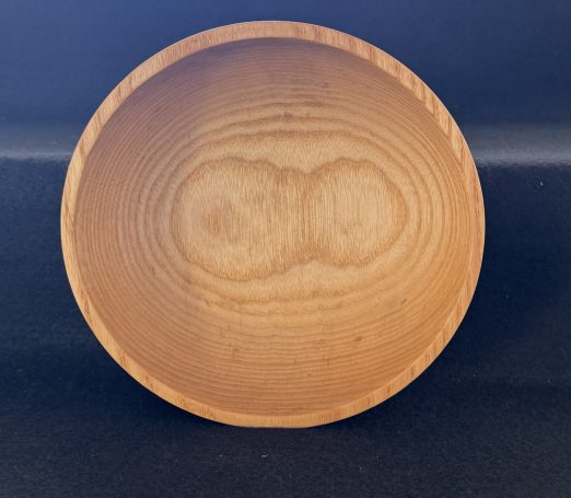 A smooth, round wooden bowl with visible grain patterns.